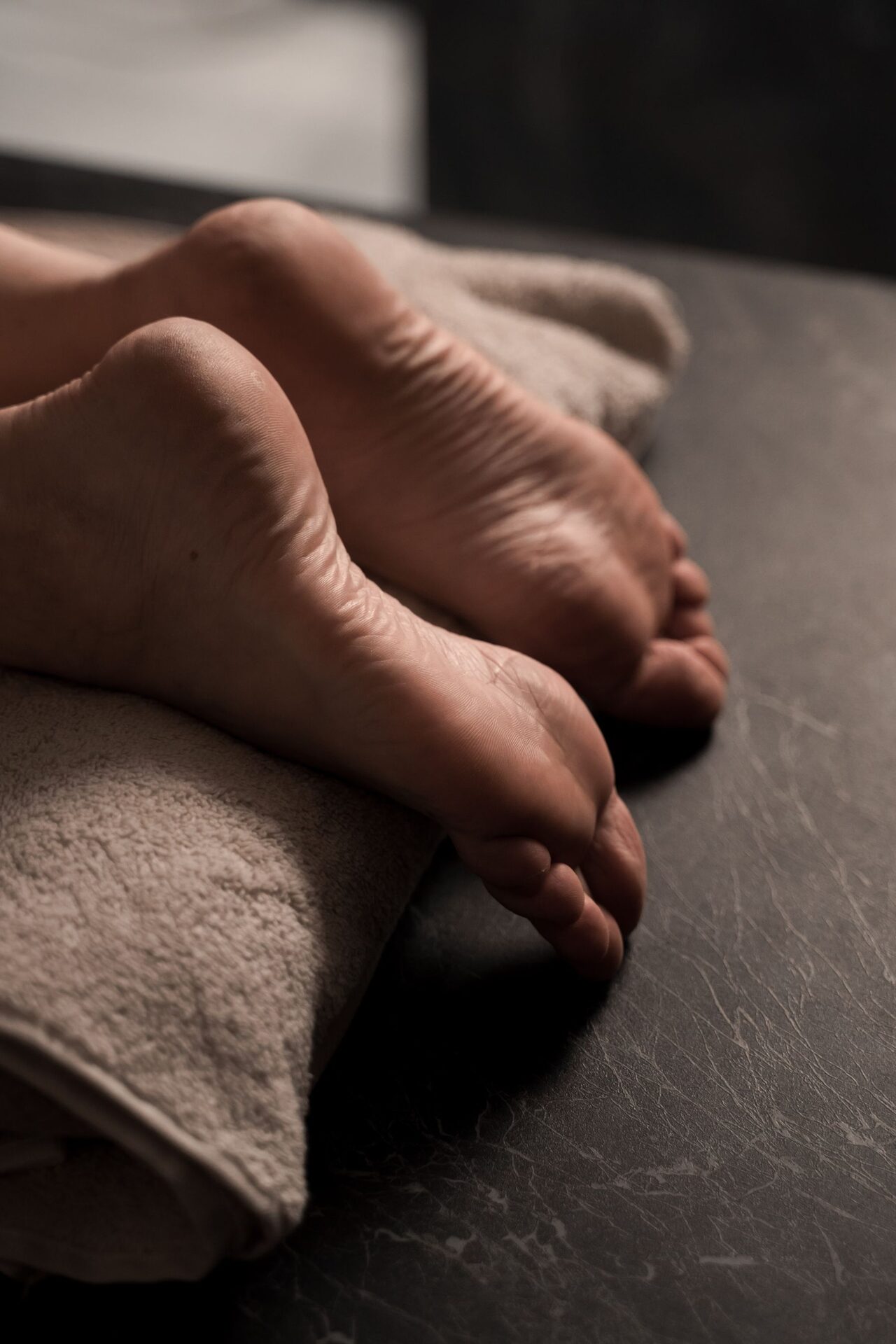 Bare feet relaxing on a soft towel — quiet, minimal foot care setting